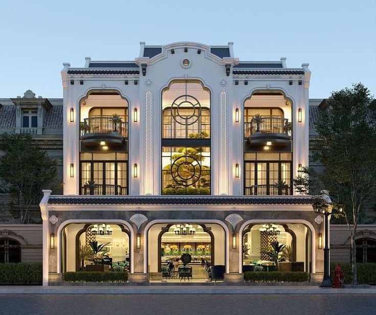 a large white building with lots of windows and lights on it's front entrance