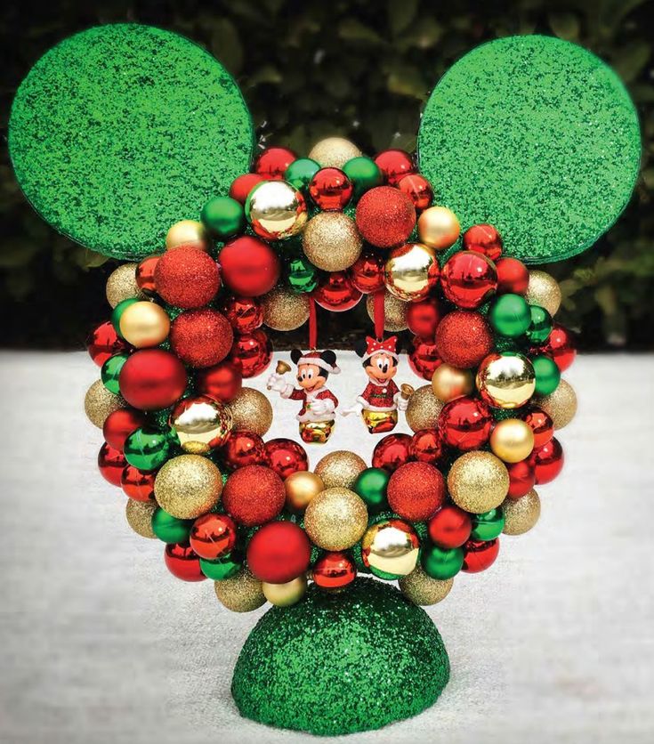 a mickey mouse christmas ornament with red, green and gold ornaments on it