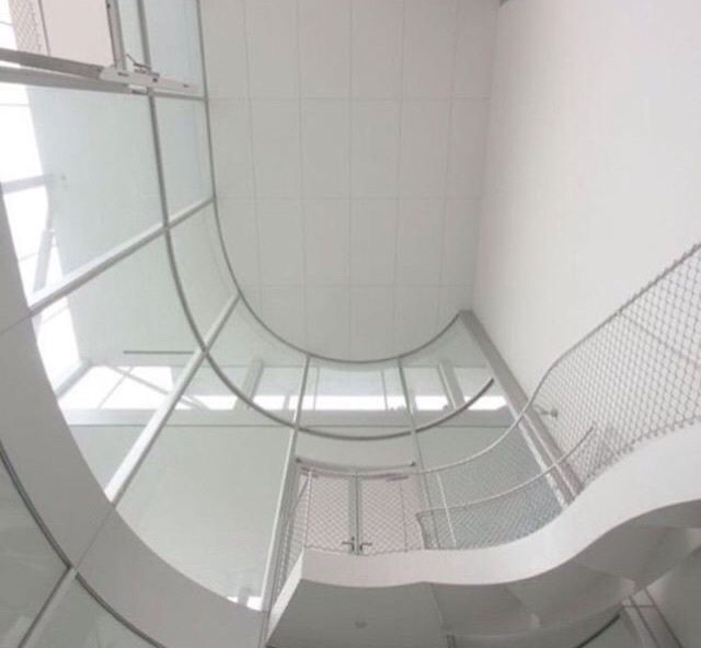 the inside of a glass and steel staircase