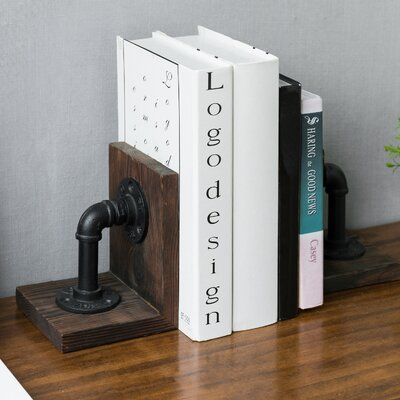 two books are sitting on top of a wooden shelf next to an iron faucet