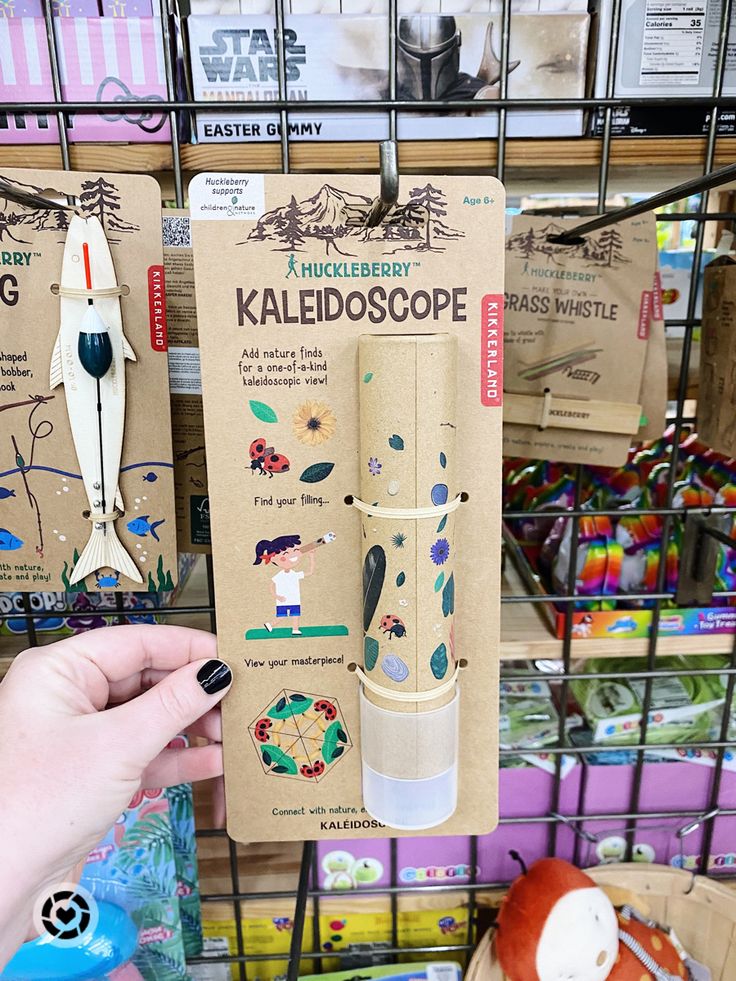 a person holding up a cardboard kaleidoscope in front of some other items