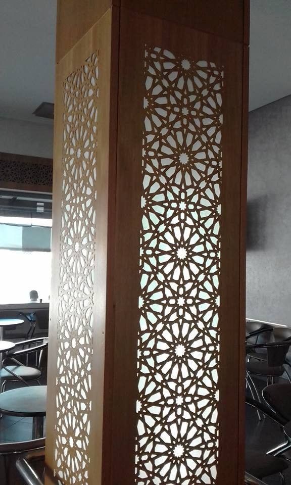 an intricate wooden screen is in the middle of a room with black chairs and tables