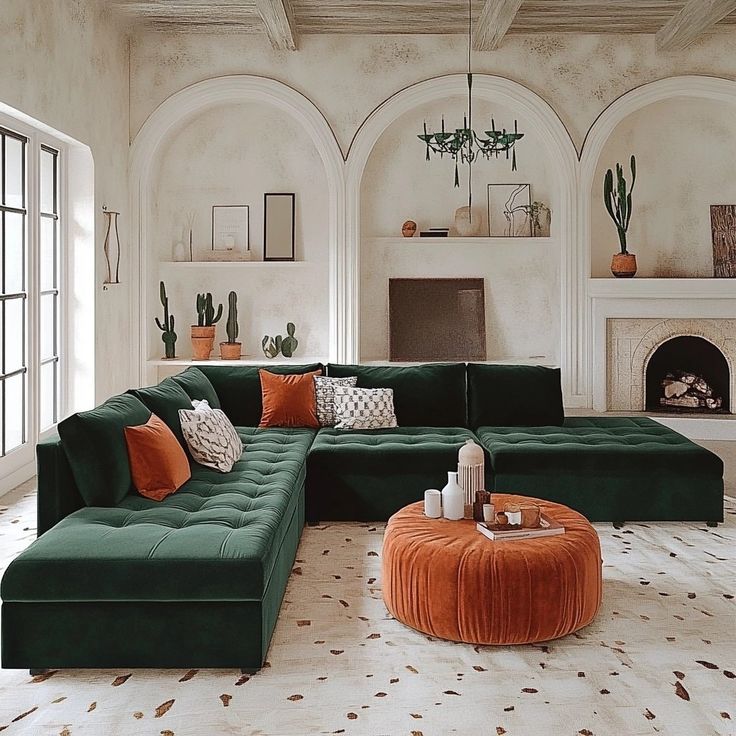 a living room with green couches and orange pillows on the floor in front of a fireplace