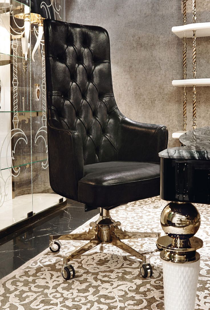 a black leather chair sitting on top of a white and gold rug in front of a mirror