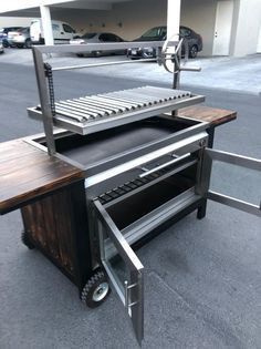 an outdoor bbq grill on wheels in a parking lot