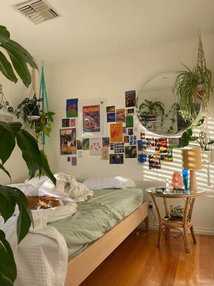 a bed sitting in a bedroom next to a table with a mirror on top of it