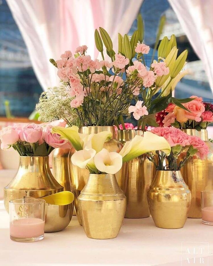 there are many vases with flowers in them on the table