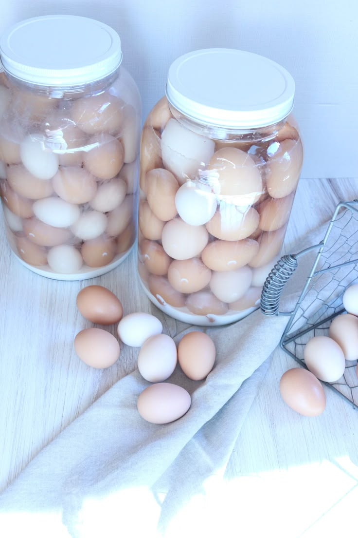 two jars filled with eggs sitting on top of a table