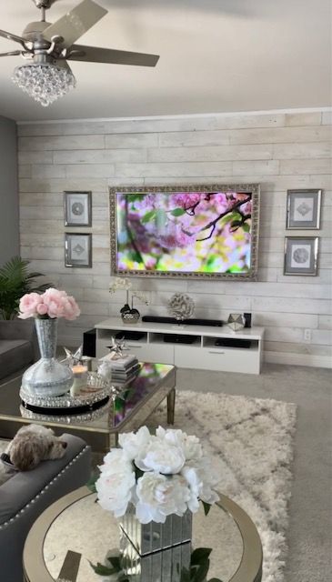 a living room filled with furniture and a flat screen tv mounted on the wall above a fireplace