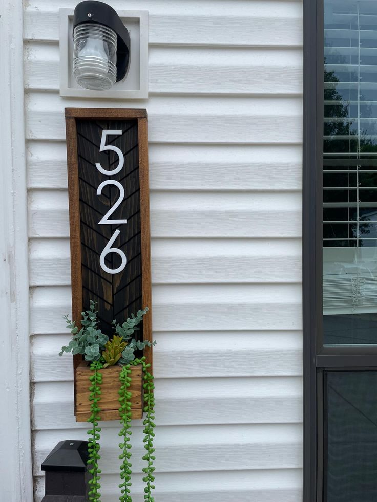 a house number sign mounted to the side of a building