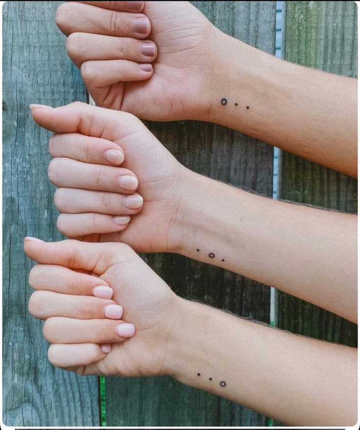 three hands holding each other with small dots on their fingers and the words love are written in black ink