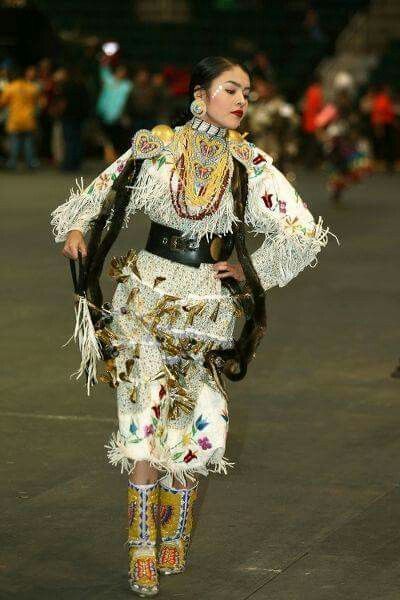 a woman is walking down the runway in an elaborate outfit