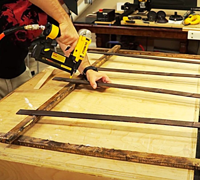 a person using a power drill to attach wood planks on a workbench