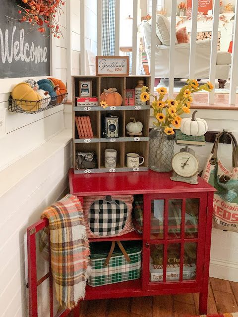 a red cabinet sitting in the corner of a room with sunflowers on it