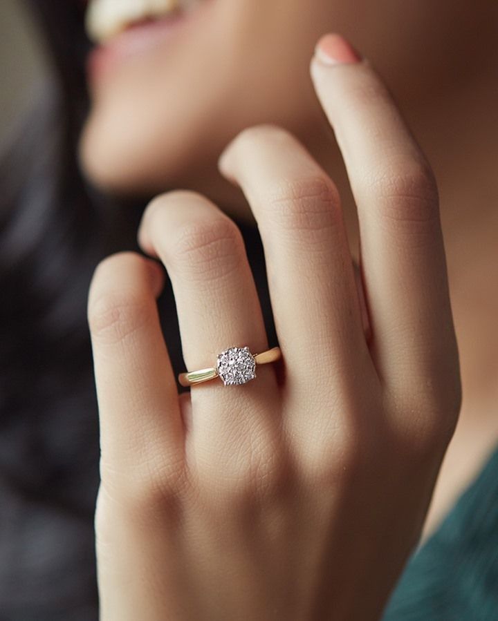 a close up of a person wearing a ring with a diamond on the middle finger