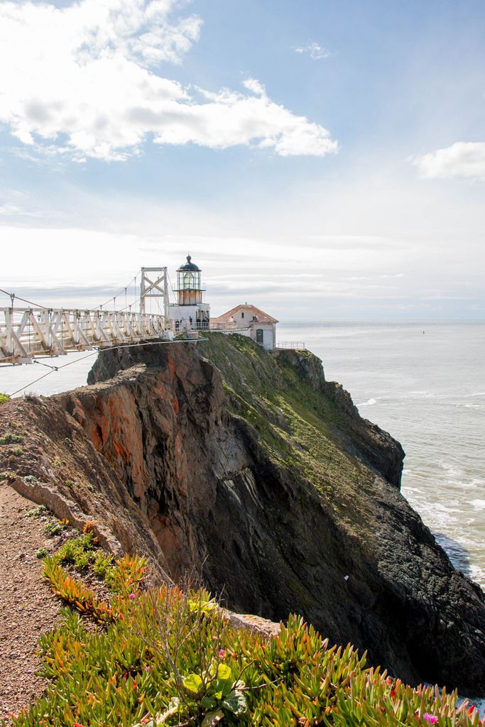 a lighthouse on top of a cliff near the ocean