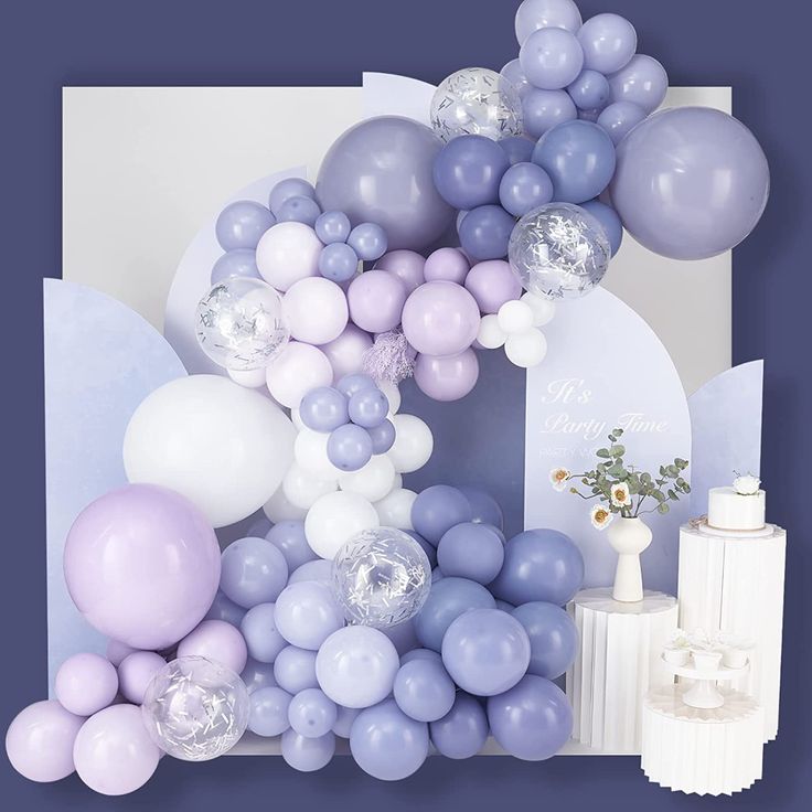 a bunch of balloons that are in front of a card and some cake on a table