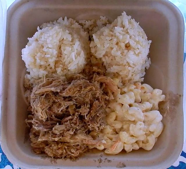 rice and meat in a plastic container on a table