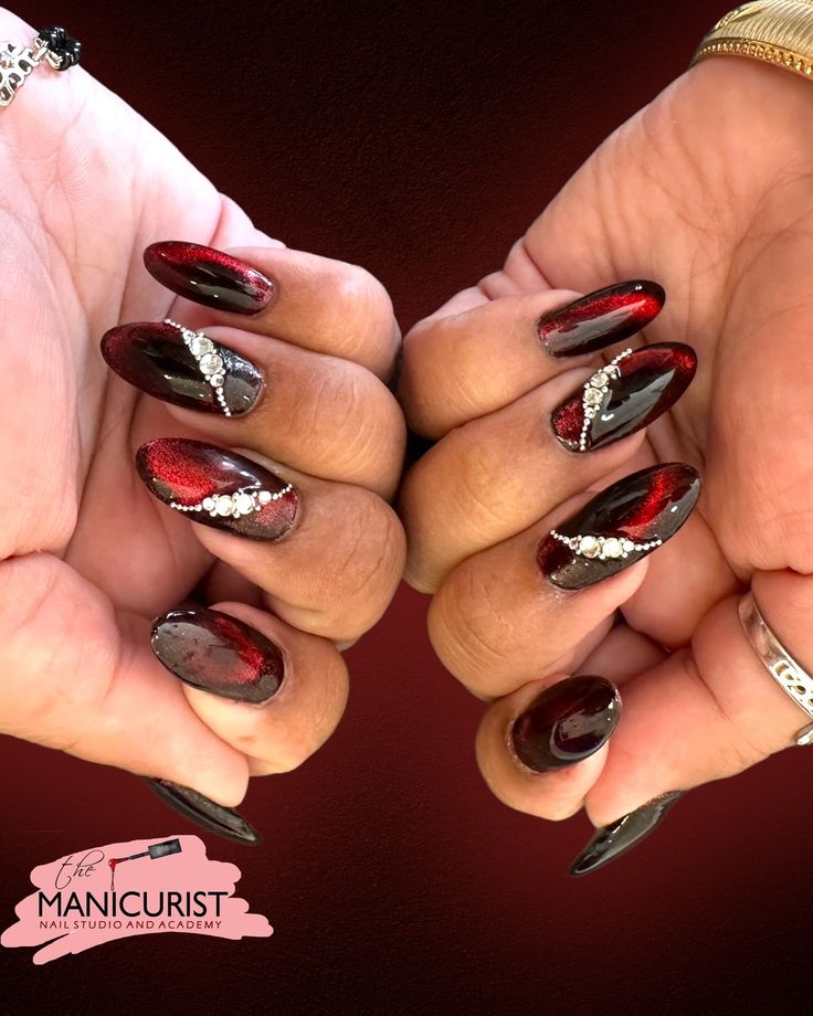 two hands with red and black manicures holding each other