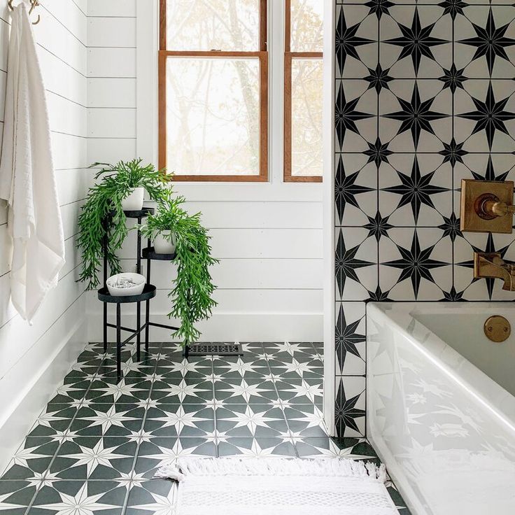 a bathroom with black and white tiles on the floor, shower curtain, and bathtub