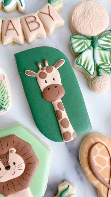 baby shower cookies decorated like giraffes, lion, and other animal items