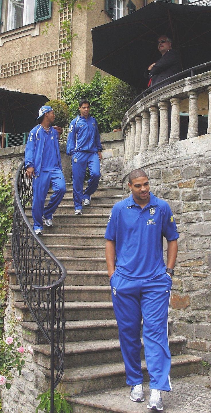 three men in blue tracksuits walking down some stairs