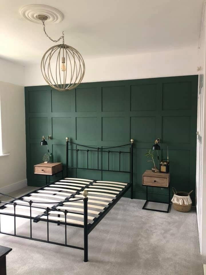 a bed room with a neatly made bed and green walls