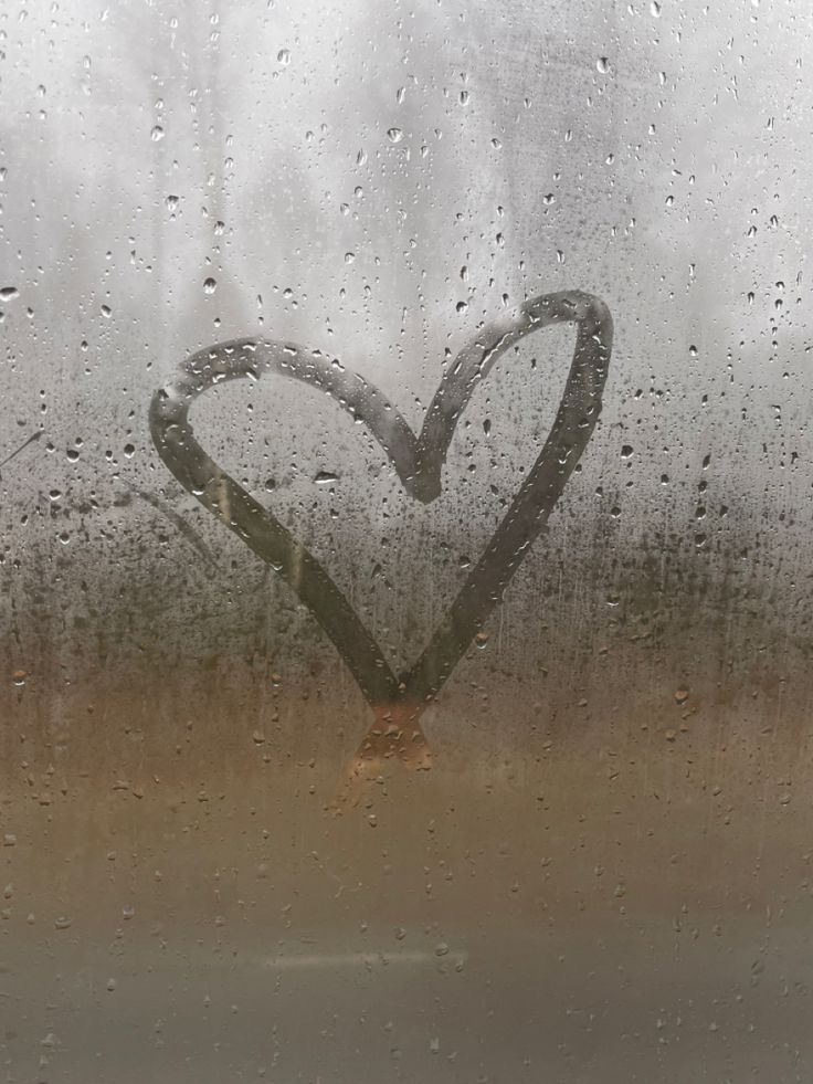 a heart drawn in the rain on a window