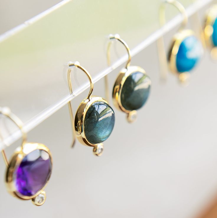 Inspired by our statement Dropping Circles earrings, we designed the Tini Mini Drops to be worn with all your everyday looks. Each semi-precious gemstone sits next to a small cubic zirconia cabochon for a subtle pop of sparkle. Add them to any outfit for colorful fun! Details Lightweight drop earrings Made of genuine labradorite and cubic zirconia stone Skillfully crafted in 14k gold plated recycled brass Nickel free and hypoallergenic Dimensions: 5/8" Wide x 1 1/8" Long Please note that due to Luxury Earrings With Natural Stones, Luxury Round Earrings With Natural Stones, Luxury Drop Earrings With Bezel Setting, Fine Jewelry Earrings With Natural Stones, Minimalist Gemstone Round Earrings, Round Minimalist Gemstone Earrings, Minimalist Round Gemstone Earrings, Modern Gemstones With Gemstone Accents For Gift, Sterling Silver Earrings With Gemstone Accents