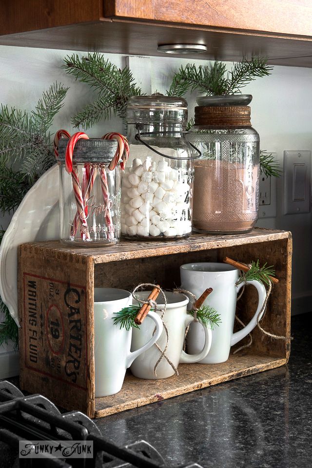 a shelf filled with mugs and candy canes on top of a wooden box