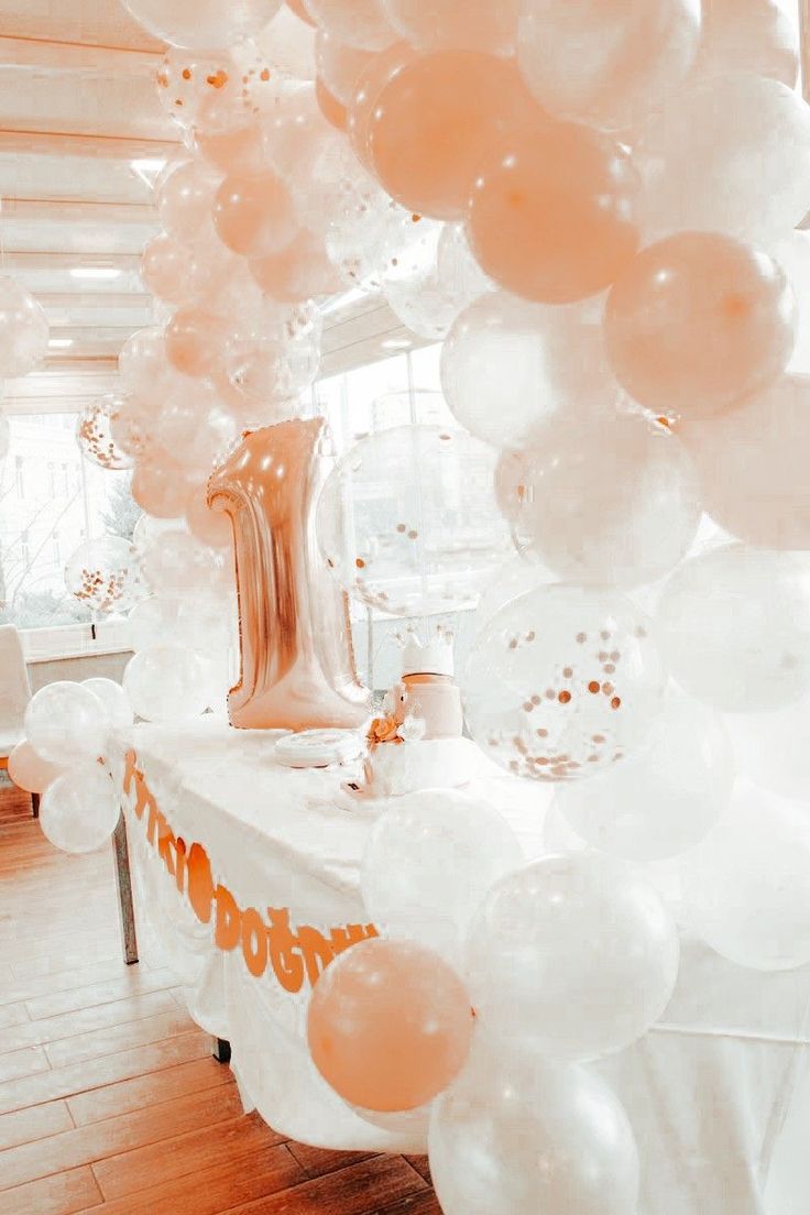 a table topped with lots of white balloons