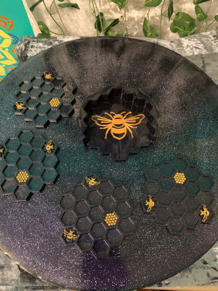 a black plate with bees and honeycombs on it