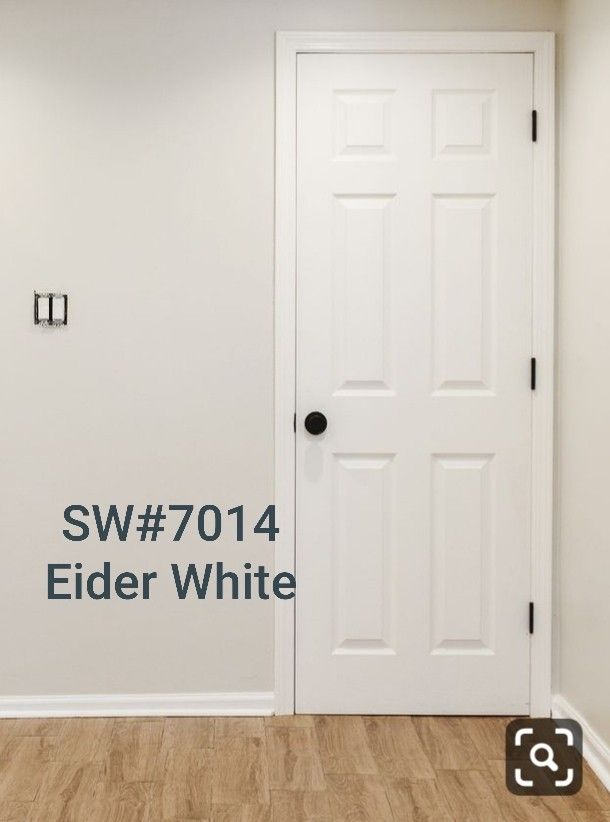 an empty room with a white door and black lettering on the wall that says sw7104 elder white