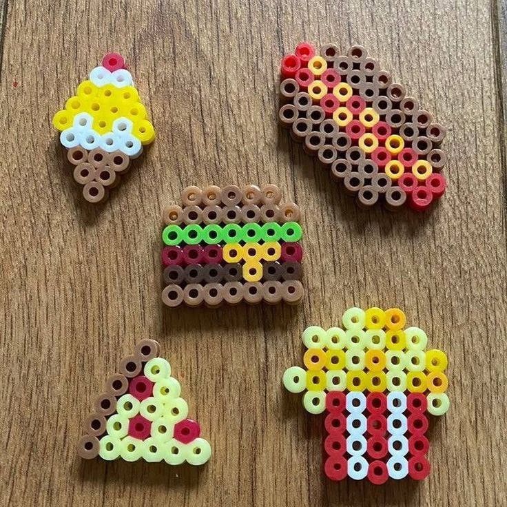 four pieces of bead art on a wooden table