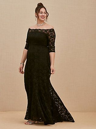 a woman in a black dress is smiling and posing for the camera with her hands on her hips