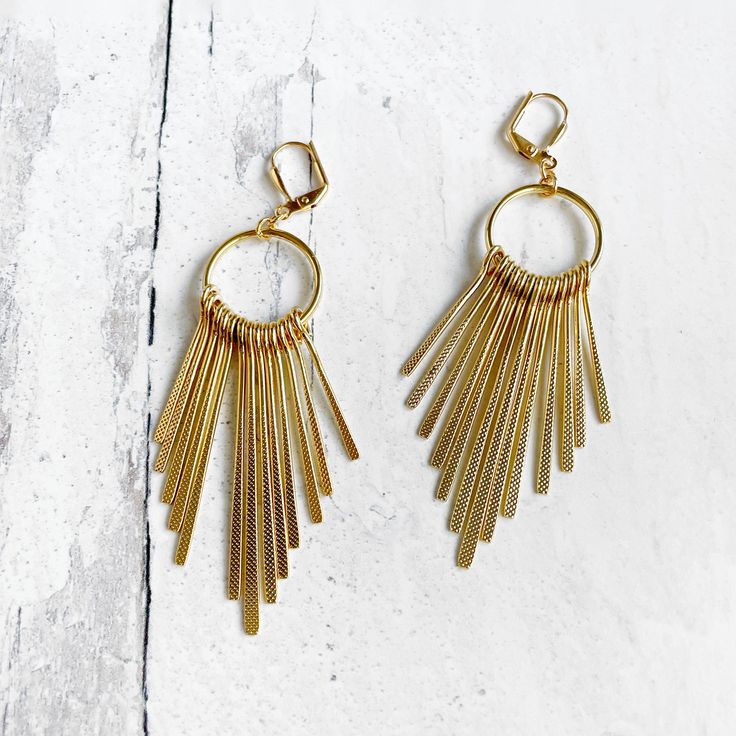 This season, glow for gold in this dramatic pair with trendy geometric shapes. MATERIAL: Gold/Silver plated brass CLOSURE: Gold/Silver plated leverback LENGTH: 3.25" long Long Fringe, Gold Geometric, Gems Jewelry, Fringe Earrings, Jewelry Case, Silver And Gold, Chandelier Earrings, Long Earrings, Stone Pendants