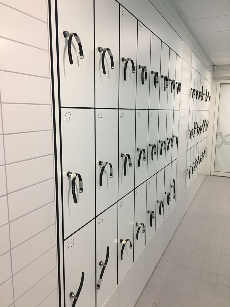 the lockers are lined up against the wall with black handles and hooks on them