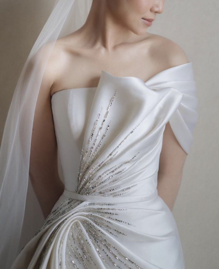 a woman wearing a white wedding dress and veil