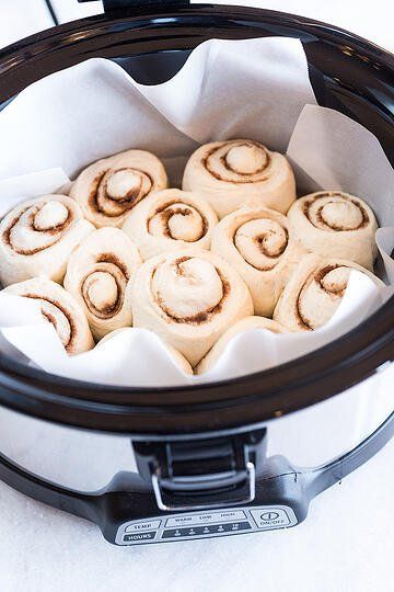 several rolls in a crock pot on a table