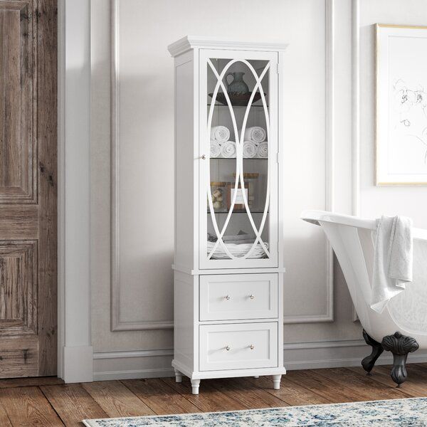 a white china cabinet with glass doors and drawers in a room next to a bathtub