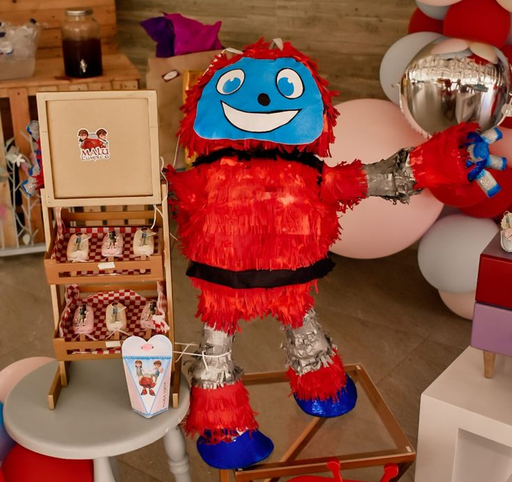 a red and blue stuffed animal standing in a room