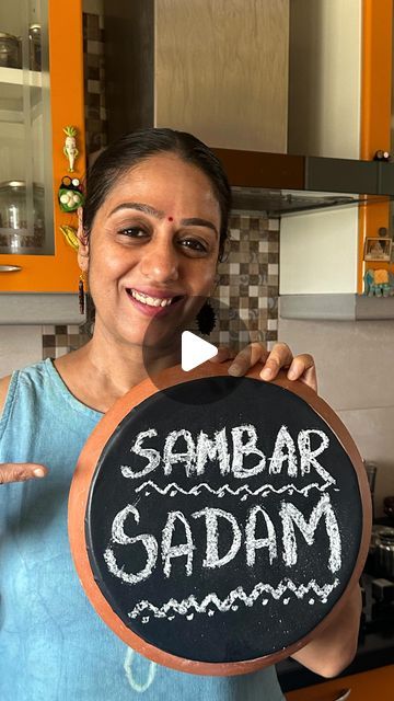 a woman holding up a sign that says sambar gaddam