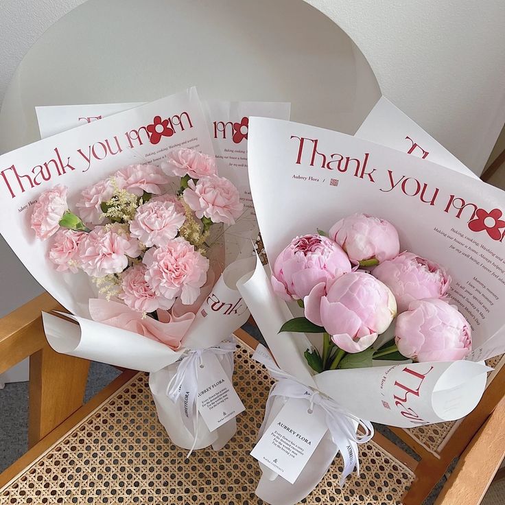 two bouquets of pink flowers are sitting on a chair