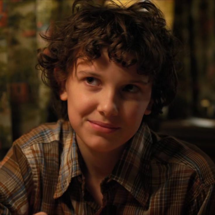 a young boy sitting at a table with a bottle of wine in front of him