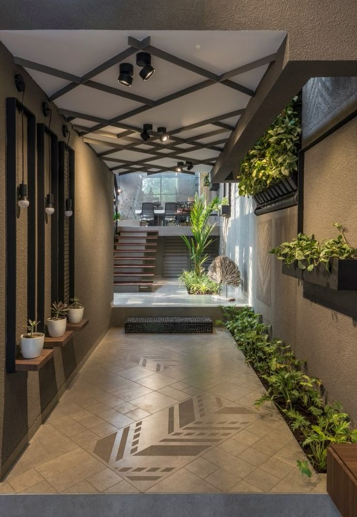 an indoor courtyard with plants and stairs leading up to the second floor, surrounded by greenery