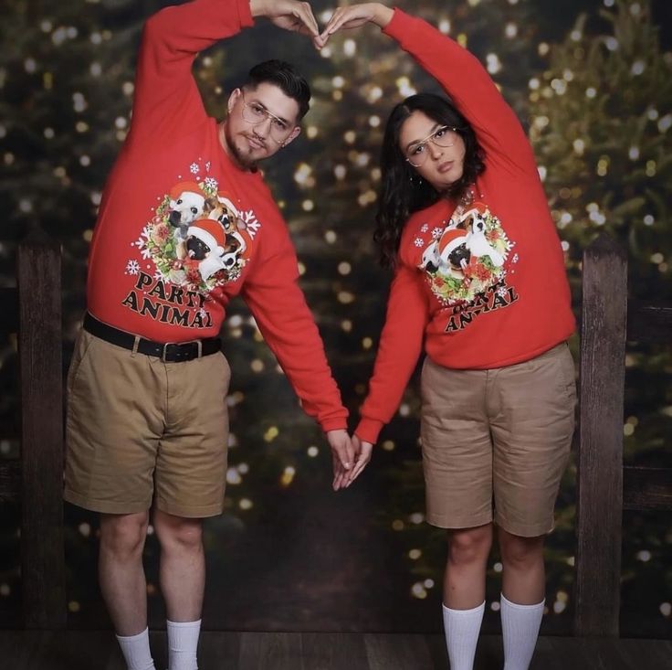 a man and woman in red sweaters standing next to each other with their hands together