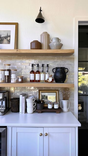 a kitchen with shelves filled with coffee cups and mugs on top of it's counter