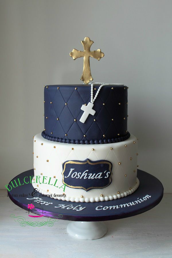 a three tiered cake with a cross and name on the top is decorated in blue, white and gold