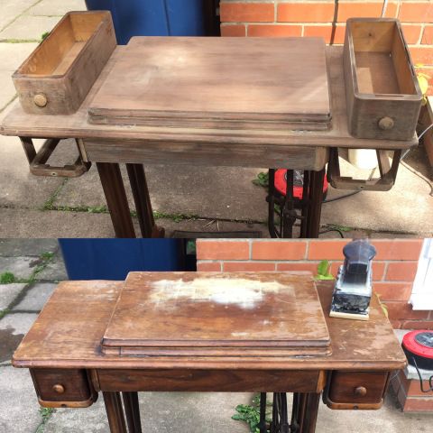 an old wooden desk with two drawers and a phone on the table next to it