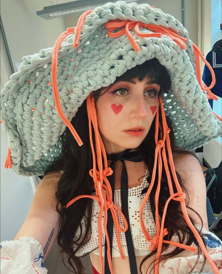 a woman wearing a straw hat with orange string attached to her head and the words let's go written on it